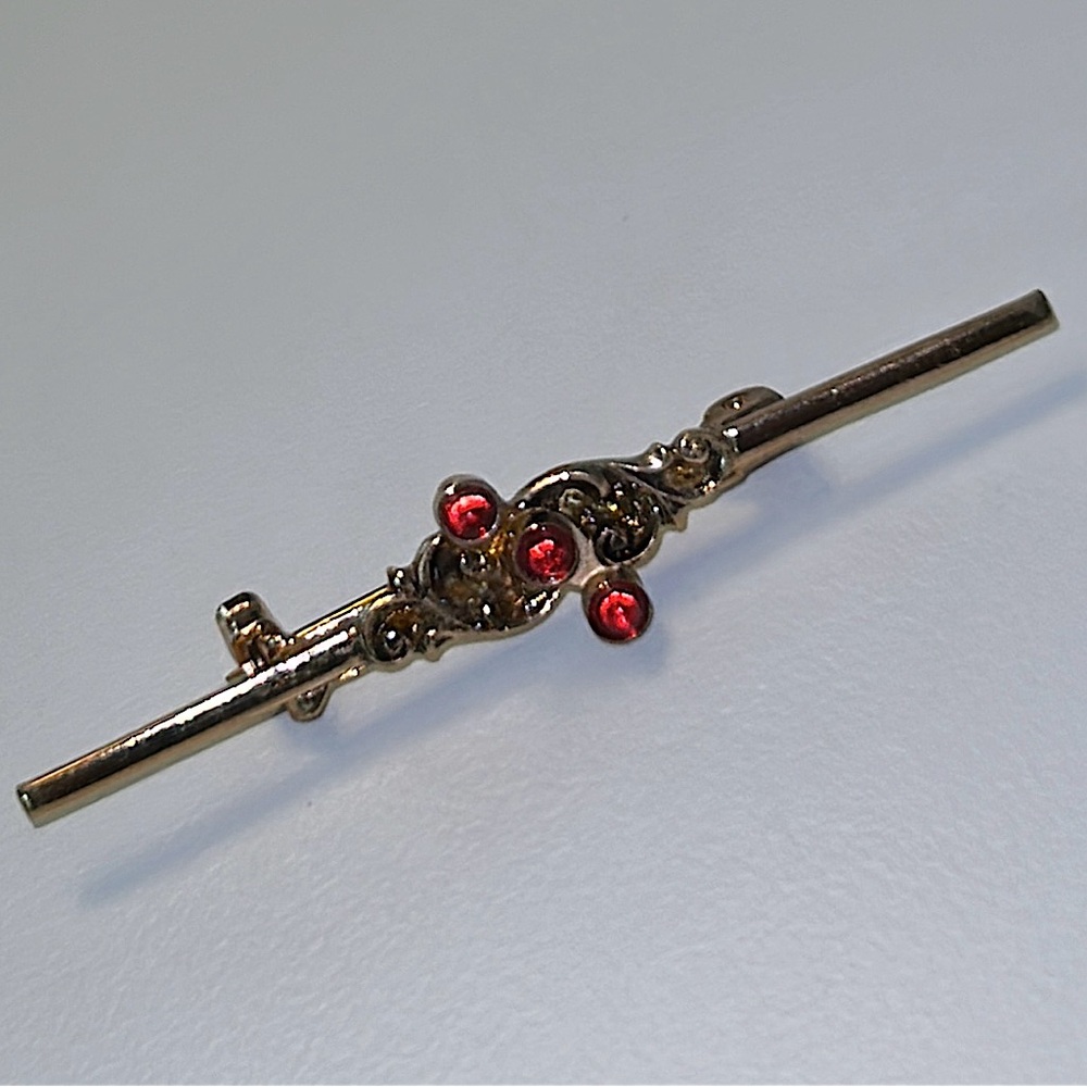 Vintage 1970s gold tone feminine bar brooch with red stones